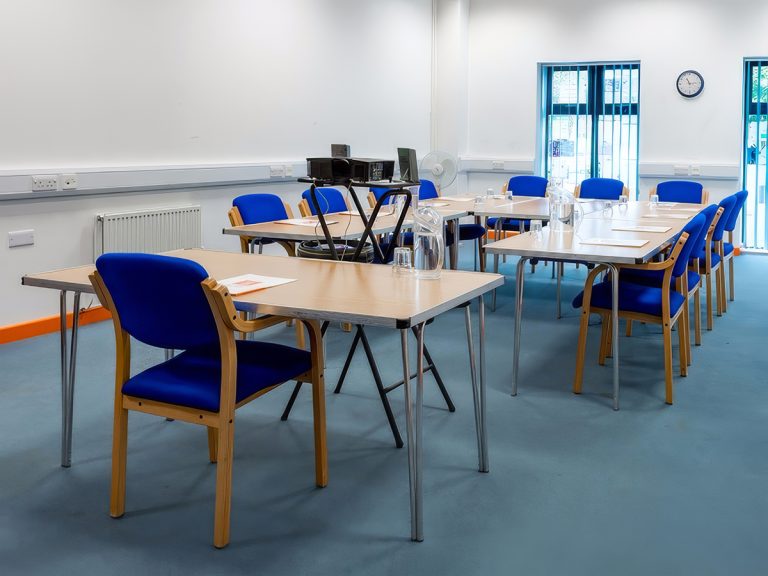 Office E in a boardroom configuration and a projector facing the screen.